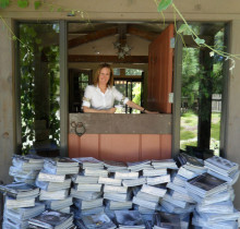 Photo of Nancy Reyering and her collection of Restoration Hardware mailings dropped off by neighbors to be returned to headquarters. 
