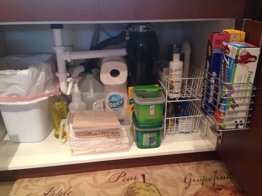 Maximize storage space under-the-sink by using a vertical organizer and over-the-door organizer.